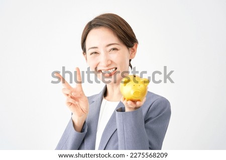 Asian businesswoman peace sign gesture with the piggy bank in white background