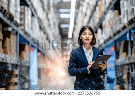 Business women use a digital tablet to manage the stock inventory on shelves in the large warehouse, smart cargo management system, supply chain and logistic network technology concept.