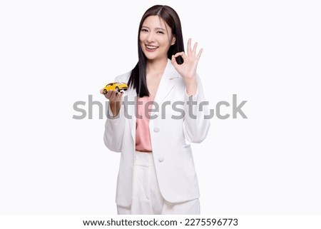 Happy young Asian business look woman shows yellow mock up car with OK hand sign isolated on white background.