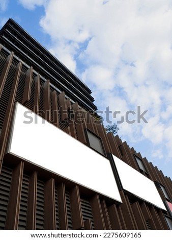 Blank mock up signage for logo or ad placements at the exterior of a modern commercial building.
