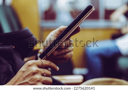 Hand of a woman looking at a smartphone