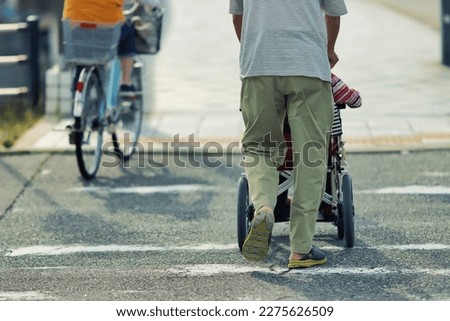 Rear view of a man pushing a wheelchair