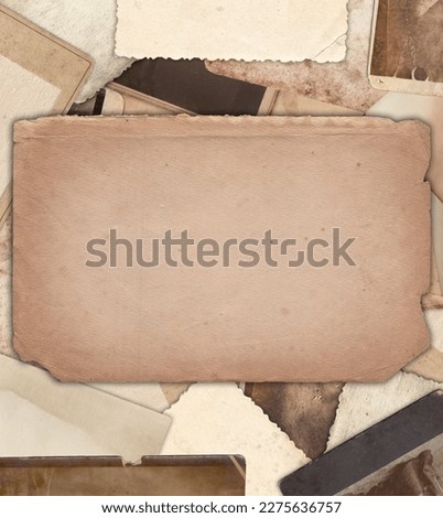 Vintage photo paper with stains and scratches on heap of old photos background