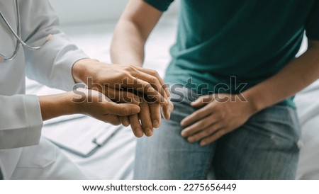 Male patient consulting a medical specialist at hospital. encouragement by holding hands