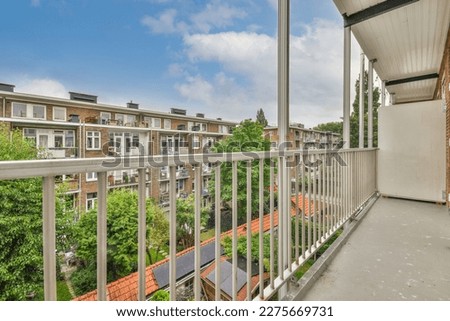 a balcony with trees and houses in the background, taken from an apartment window looking out to the street below Royalty-Free Stock Photo #2275669731
