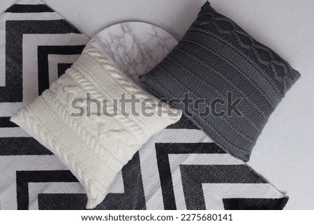 Soft comfortable beautiful knitted pillows on the floor. Geometric picture.