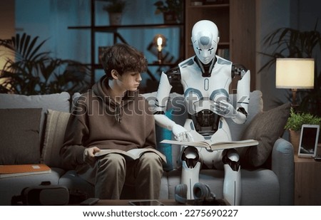 Innovative AI robot tutor helping a teenage boy with homework, they are reading books together, human-robot interaction concept Royalty-Free Stock Photo #2275690227