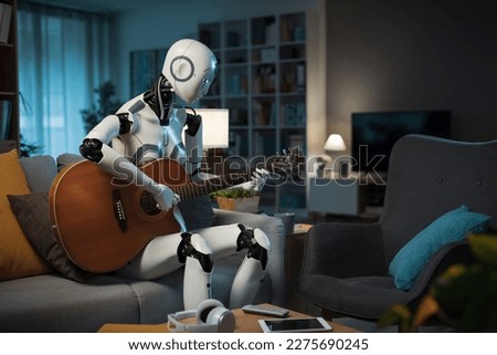 A Robot equipped with A.I. practices playing the guitar. He learns quickly, and is very skillful. Royalty-Free Stock Photo #2275690245