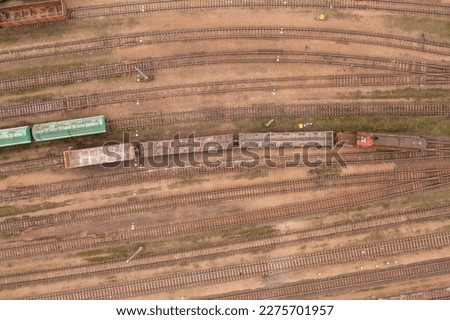 Drone photography of railway depot, cargo carriages and train during winter cloudy day