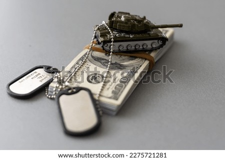 Army identification medallions and dollar bills on United states flag. Military pension, salary in the army or military insurance Royalty-Free Stock Photo #2275721281