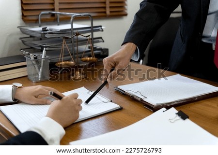 Law firms discussing with pen pointing at documents drafting or amending contracts in law firm office Royalty-Free Stock Photo #2275726793
