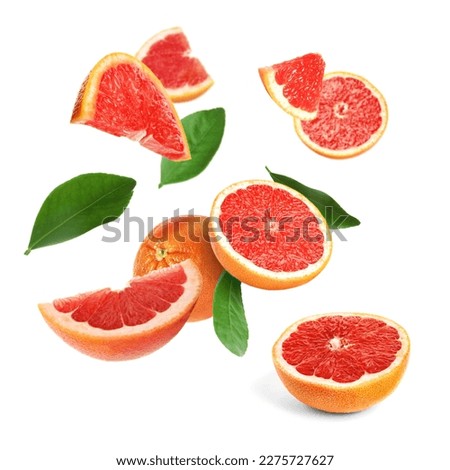 Cut fresh grapefruits and green leaves flying on white background Royalty-Free Stock Photo #2275727627