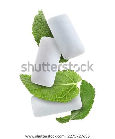 Fresh mint leaves and chewing gum pads falling on white background Royalty-Free Stock Photo #2275727635