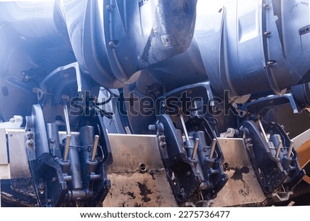Lifting mechanisms on outboard motors at the stern of the boat. Transom lift on outboard motors of a motor boat. Royalty-Free Stock Photo #2275736477