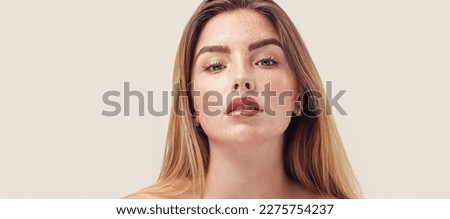 Studio beauty portrait of young natural woman with freckles on her face. Girl looking at the camera. A lot of copy space. Skin care concept. Ideal, delicate makeup with lipstick. Royalty-Free Stock Photo #2275754237
