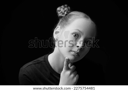 Black and white portrait of a beautiful girl who looks calmly and thoughtfully at the camera. Psychological picture. Children, emotions.