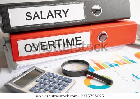 Salary, Overtime. Binder data finance report business with graph analysis in office. Royalty-Free Stock Photo #2275755695