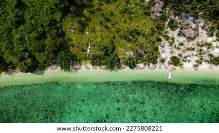 aerial view of a fishing village at the island of darocotan in philippines with coast and many palm trees and some fish boats