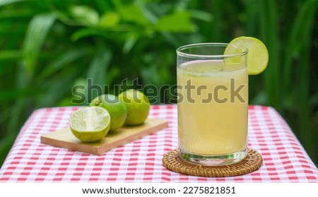 Fresh drink lime juice in the glass on panda leave background. Glass filled with fresh made lemon Juice vitamin drink.