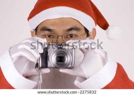 Asian Santa Claus holding a digital camera.
