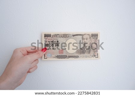 Japanese yen with woman's hand Royalty-Free Stock Photo #2275842831