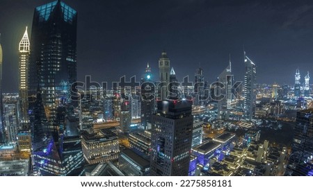 Panorama of futuristic skyscrapers in financial district business center in Dubai on Sheikh Zayed road night . Aerial view from above with illuminated towers