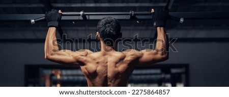 Athletic pulling up showing back muscle at gym. Muscular man exercise pull up on bar in fitness gym. Bodyweight workout. Banner ratio. Royalty-Free Stock Photo #2275864857