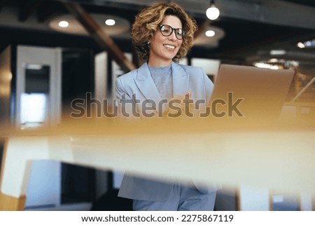 Caucasian business woman having a video call in a coworking office. Professional business woman having an online meeting. Female professional doing remote work with a laptop. Royalty-Free Stock Photo #2275867119