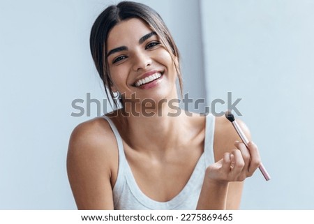 Shot of beautiful young woman making make-up near mirror in the bathroom. Royalty-Free Stock Photo #2275869465