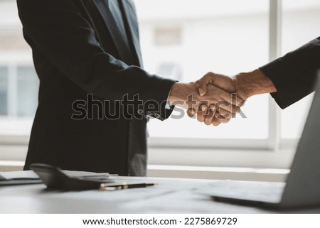 Business investor group holding hands, Two businessmen are agreeing on business together and shaking hands after a successful negotiation. Handshaking is a Western greeting or congratulation. Royalty-Free Stock Photo #2275869729