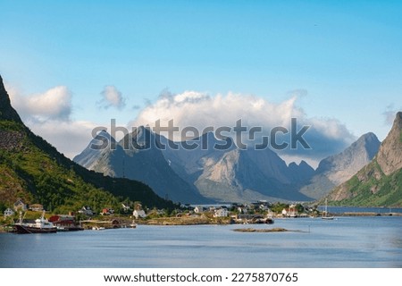 The most famous fishing village Reine with traditional red fisherman's cabins on Lofoten islands, Nordland, Norway. Amazing nature with dramatic mountains and peaks, open sea, pier and bay Royalty-Free Stock Photo #2275870765