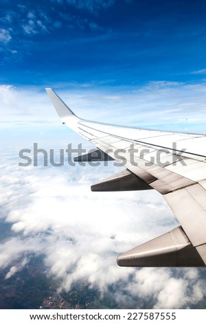 Aircraft wing on the clouds,flying background Royalty-Free Stock Photo #227587555
