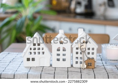 Key to house of cozy home on table of kitchen. Building, design, project, moving to new house, mortgage, insurance, rent and purchase real estate Royalty-Free Stock Photo #2275882309