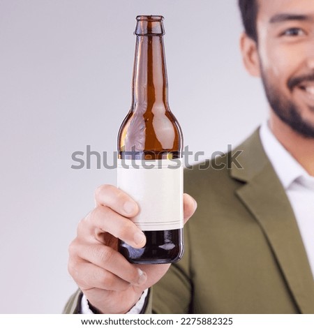 Man face with beer bottle isolated on a white background for alcohol product promotion drink, happy hour and cheers. Professional Asian person or model hand holding wine glass container in studio