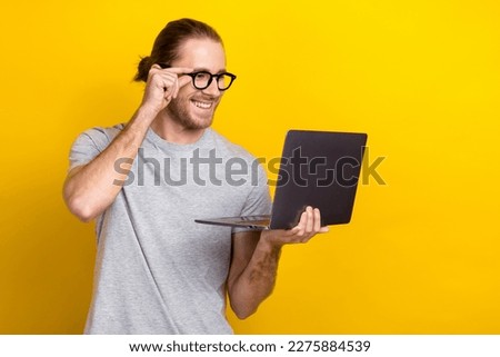 Photo of glad positive bearded man wear stylish clothes hold macbook read email telegram news isolated on yellow color background
