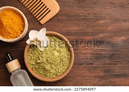 Flat lay composition with henna and turmeric powder on wooden table, space for text