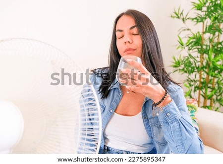 Woman suffering summer heat trying to stay cool and comfortable during heat wave Royalty-Free Stock Photo #2275895347