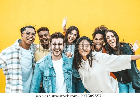 Multiracial group of young people standing in front of yellow isolated background - Youth community concept with guys and girls laughing looking at camera - Bright colors  