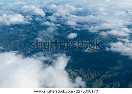 Views of fluffy clouds and complex mountains, pictures taken from the windows on the plane