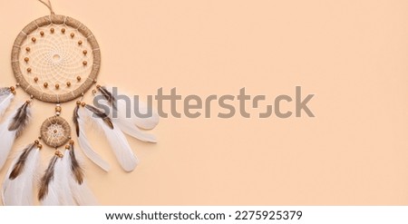 Beautiful dream catcher on beige background with space for text