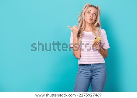Photo of youngster girl blogger new phone look direct finger empty space fast speed 5g connection internet isolated on aquamarine color background