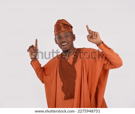 African man wearing Yoruba Nigerian native traditional attire agbada excited surprised smiling happy