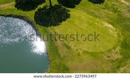 Aerial view of an empty golf course with a lake. There is no one in the sports club. Sports concept.