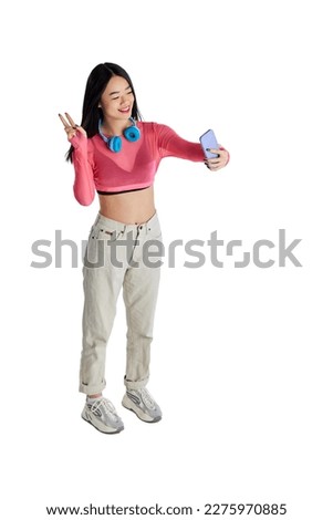 Top view. Young smiling cheerful girl in casual clothes taking selfie with mobile phone, having video call isolated on white background. Concept of business, education. lifestyle. Copy space for ad Royalty-Free Stock Photo #2275970885