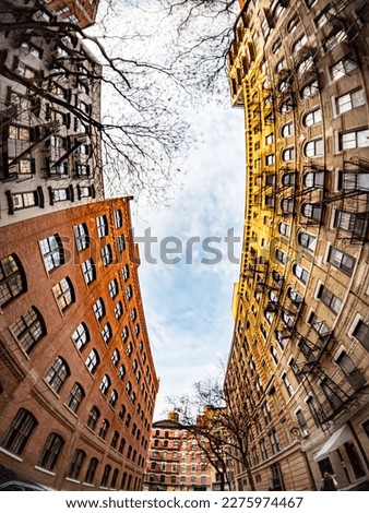 Looking up at a vertical view of a block of old buildings in New York City with a fisheye lens effect