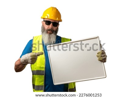 Construction worker with beard and sunglasses pointing his finger at a blank blackboard, isolated on white background.