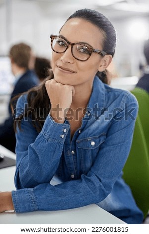 Im making the right decisions. Confident businesswoman smiling at the camera while sitting at her desk.