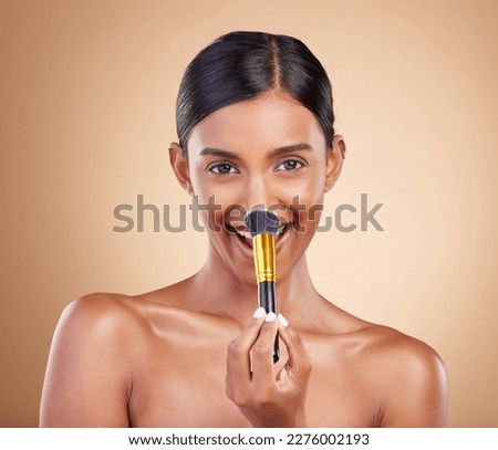Portrait, makeup brush and blush with a model woman in studio on a beige background to promote beauty. Face, nose and blusher with an attractive young female posing for cosmetics or luxury wellness