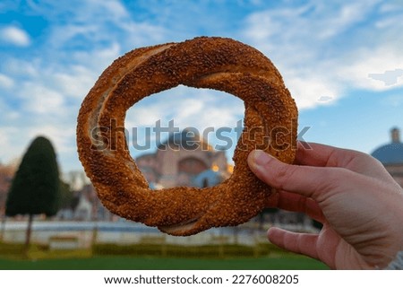 Travel to Istanbul concept photo. Simit or Turkish Bagel and Hagia Sophia on the background. Selective focus on foreground.