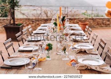 Table decor for a festive lunch or al fresco dinner in orange, yellow and green. The table is decorated with flowers and candles.

 Royalty-Free Stock Photo #2276010527